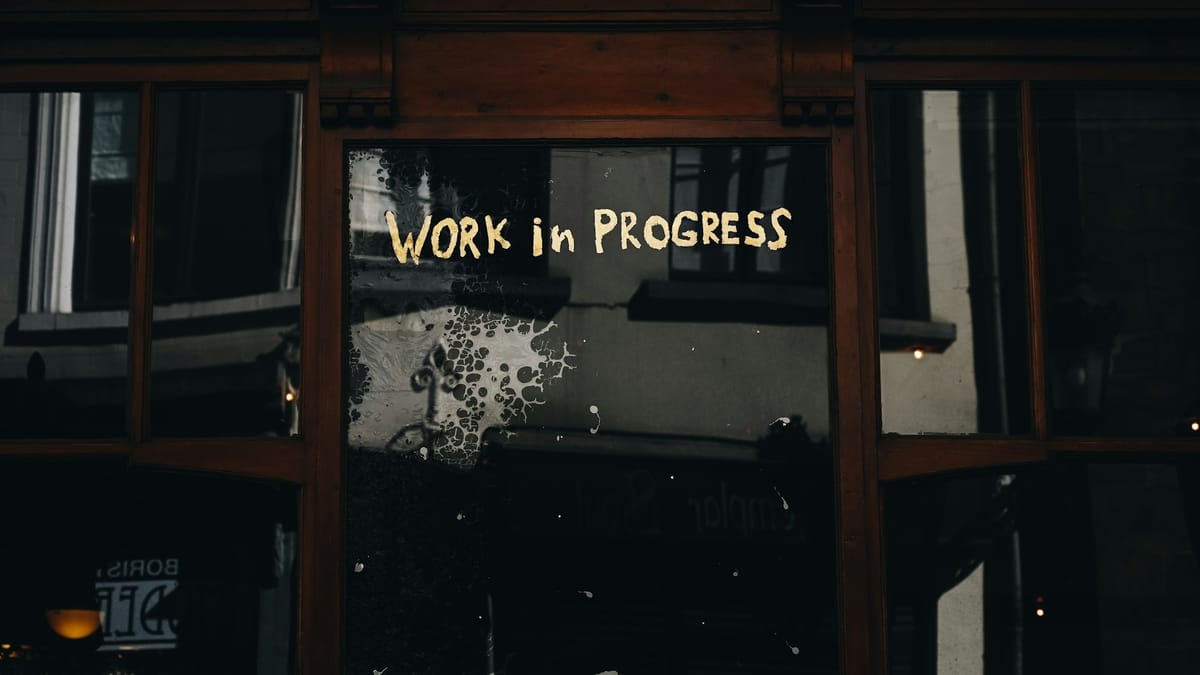 Words written on a glass door says "Work in progress"